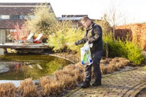 Gert-Jan Schonenberg is kalk aan het strooien in de tuin